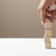 Hand arrange four empty wooden cube blocks stack on white table. - PhotoDune Item for Sale