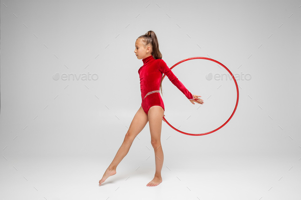 Rhythmic gymnastics. Gymnast girl performs an exercise with hoop in an red  swimsuit Stock Photo by OlhaRomaniuk