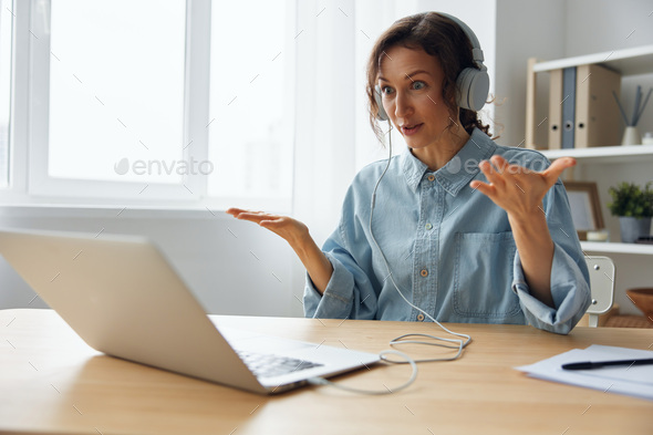 Irritated businesswoman actively gesticulating holds meeting using computer app, distant