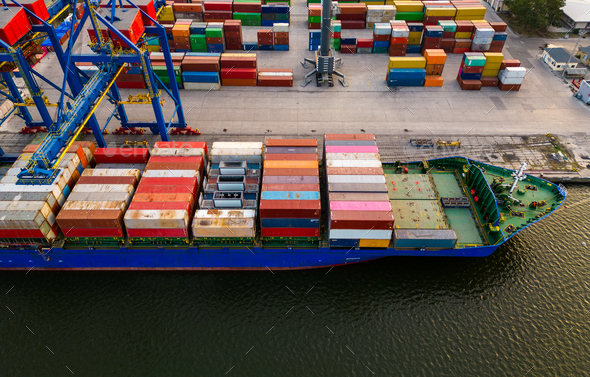 Aerial View Of A Container Ship In Terminal At The Port Where Massive Containers Await Their