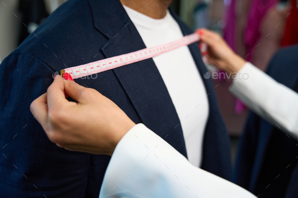 Tailor couturier measuring cloth. Closeup of sewer woman hands