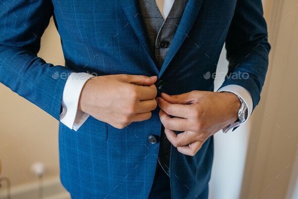 a man wearing a suit and tie with his hands on his waist