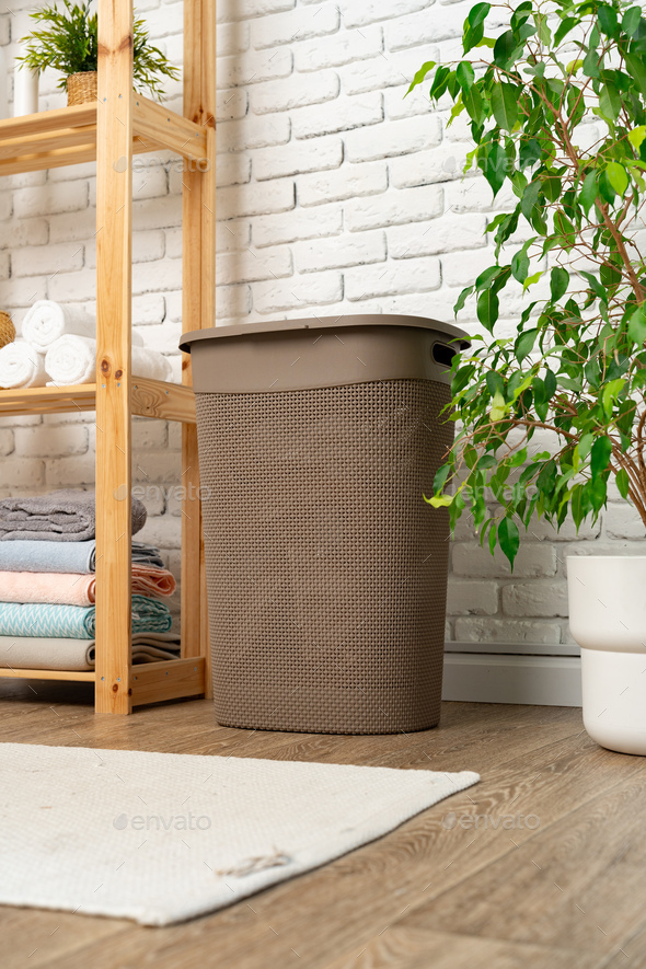 Pile of clothes in plastic laundry basket in the bathroom Stock Photo