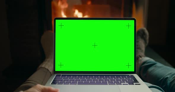 Couple Use Laptop with Chromakey Green Screen at Fireplace Watching Movie Online