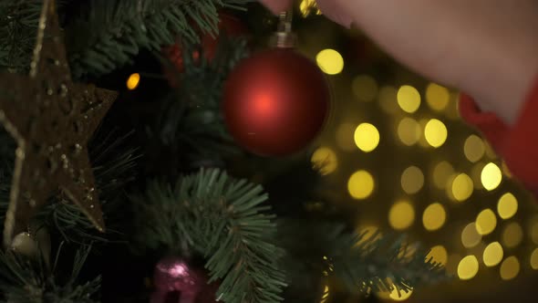 Closeup of Woman Hands Decorating Christmas Tree alt
