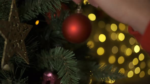 Closeup of Woman Hands Decorating Christmas Tree