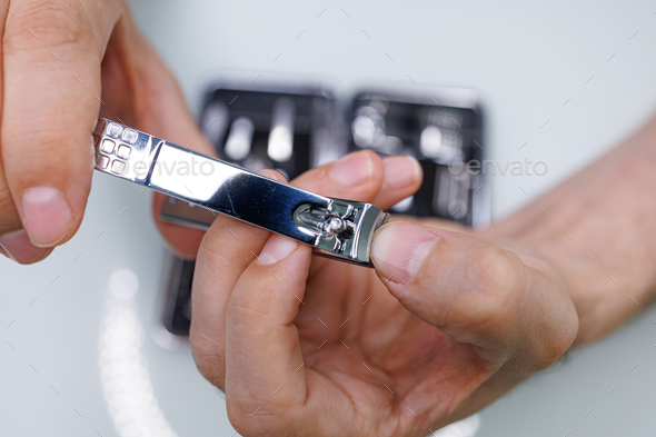 Cut the nail with manicure clippers. A man gives himself a manicure
