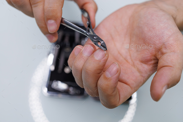 Cutting the nail with professional manicure scissors. A man gives himself a manicure
