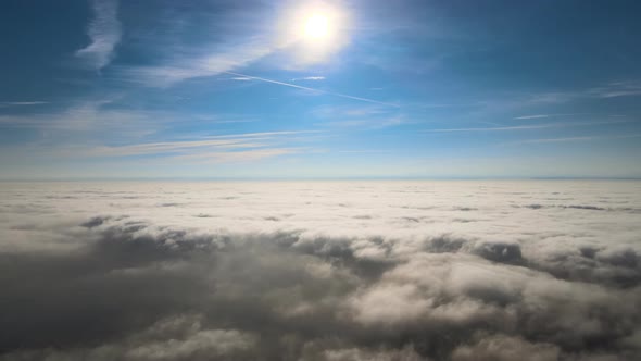 Aerial View From High Altitude of Earth Covered with White Puffy Cumulus Clouds on Sunny Day alt