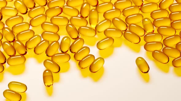 Fish oil capsules falling on white surface forming a pile. Vitamins, omega 3