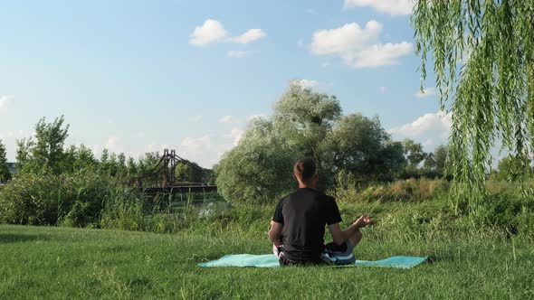 Meditating outdoors. Man made yoga practice part of existence. alt