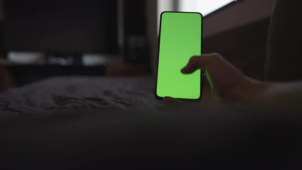 POV Man Using Phone with Green Screen Lying on a Couch