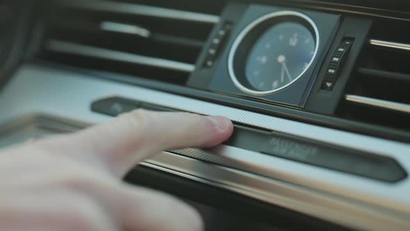 Close-up of Male Caucasian Hand Pressing Emergency Light Button on Car Dashboard