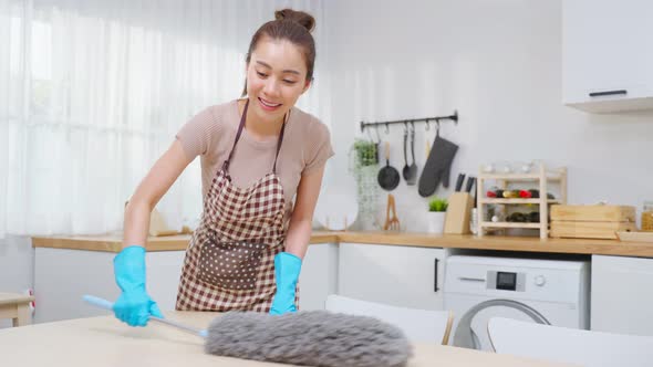 Asian cleaning service woman worker cleaning in kitchen room at home. alt