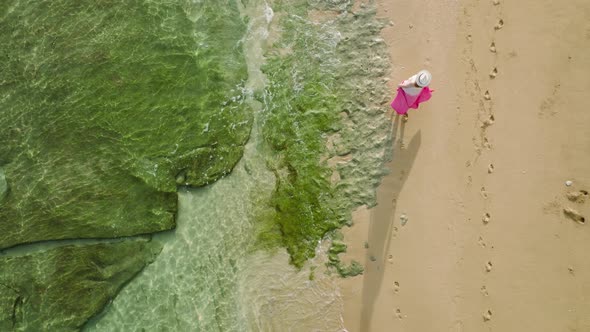 Drone Following Traveler Woman in Pink Dress Walking By Hawaii Beach Slow Motion alt