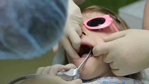 Little girl in dentist's chair having her tooth treated