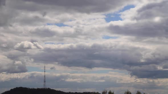 4K time lapse: television tower and beautiful fluffy clouds floating near. alt