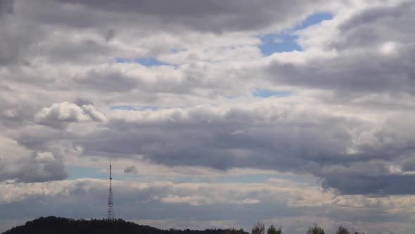 4K time lapse: television tower and beautiful fluffy clouds floating near.