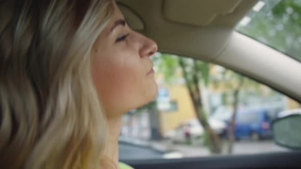 Lifestyle Beautiful Young Female Driver Has Fun Dancing to Music While Driving Car on Road in City alt