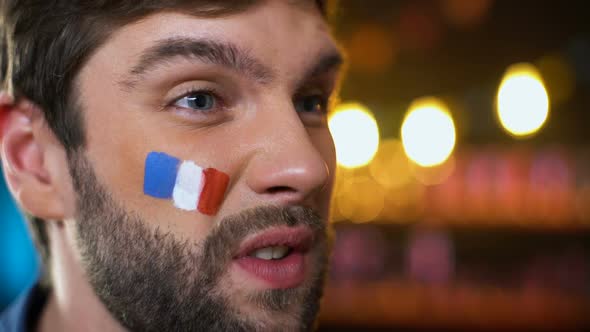 Anxious French Fan With Painted Flag on Cheek Making Facepalm, Disappointment