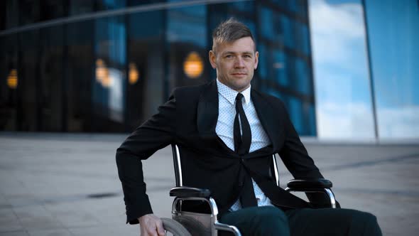 Disabled Handicapped Businessman Unfolds on Wheelchair Outdoor alt