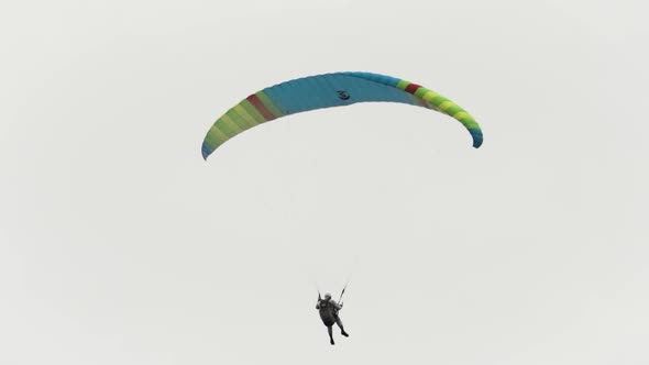 Flying parachutist against the cloudy sky alt