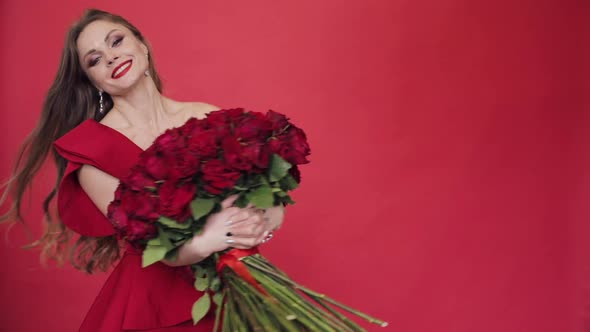 Gorgeous Woman in Red Dress Spinning with Bouquet of Roses