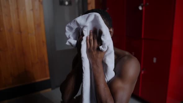 Africanamerican Athletic Young Man Wipes Off His Head with a Towel in Locker Room alt