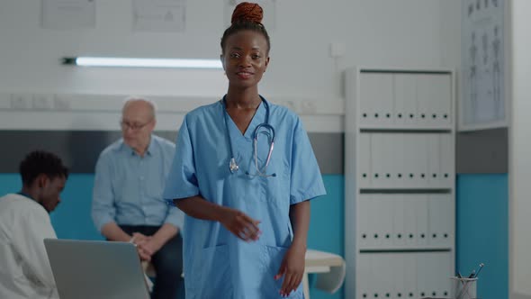 Portrait of Medical Assistant Wearing Uniform Standing in Cabinet alt