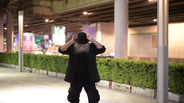 Mature Bearded Tourist Man Dancing in the City Streets at Night