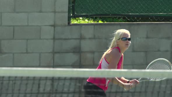 Women playing tennis. alt