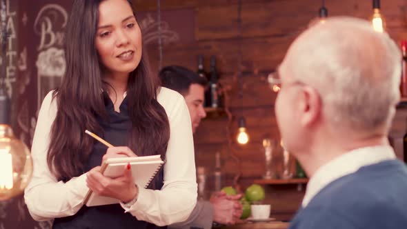 Beautiful Waitress Taking an Order From Old Man with Glasses alt