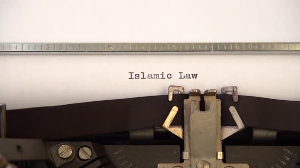 Typing phrase Islamic Law on retro typewriter. Close up. alt