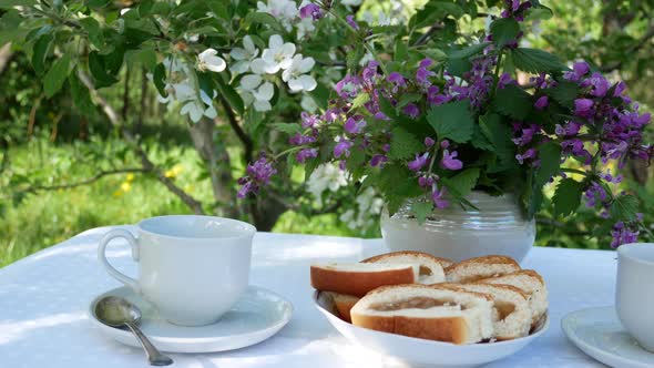 Breakfast in the Spring Garden on a Table with a White Tablecloth Served for a Tea Party