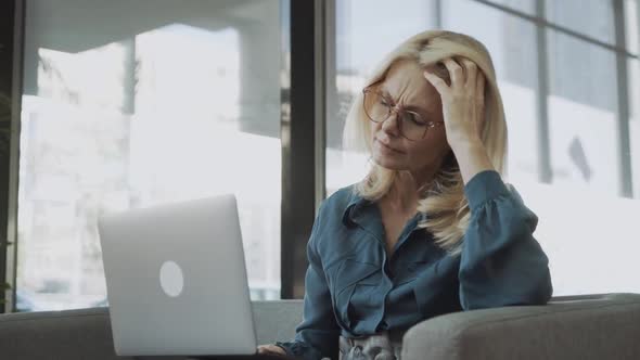 Tired Stressed Upset Middle Aged Mature Woman Feeling Sick Headache After Computer Work Sit on Sofa alt