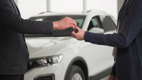 Vehicle Purchase Happy Male Buyer Takes Keys to a New Car and Shakes Hands with Auto Dealership