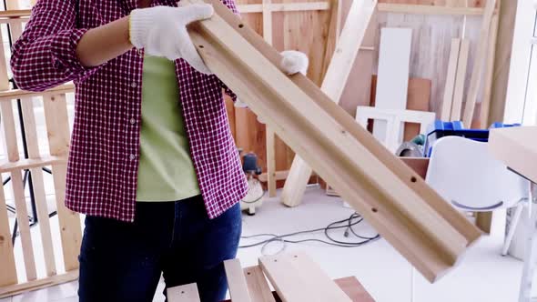 Stylish craftswoman working in carpentry. Woodwork and furniture making concept. alt