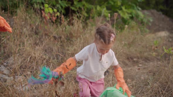 Little Girl Helps Mother Collects Plastic Garbage on Nature to Save Environment From Pollution alt