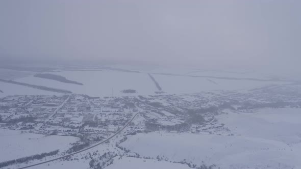 View of the Russian Village Through the Clouds in Winter at Dusk