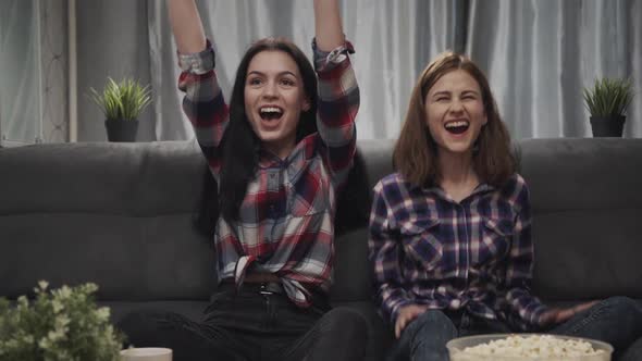 Two Girl Watching Football Together at Home