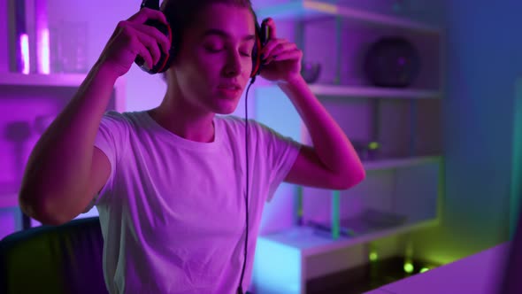 Closeup Focused Gamer Putting Headphones at Home Room alt