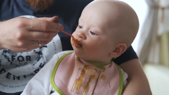 close-up of a baby being spoon-fed puree