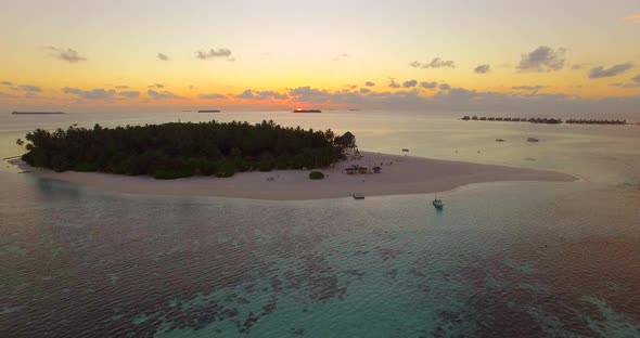 Aerial drone view of a scenic tropical island in the Maldives at sunset alt