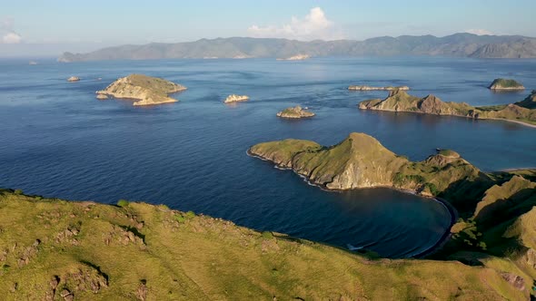 South Padar island east of Komodo Indonesia with calm inlet bays, Aerial pan right wide shot alt