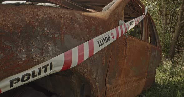 Police tape on a burned out car