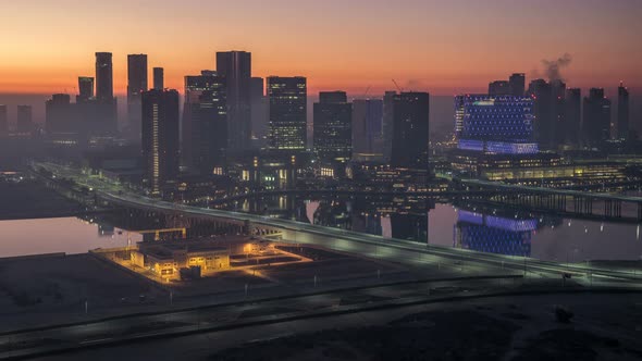 Abu Dhabi City Skyline with Skyscrapers Before Sunrise From Above Night to Day Timelapse alt