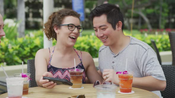 Group of friends in Hawaii looking at phone together