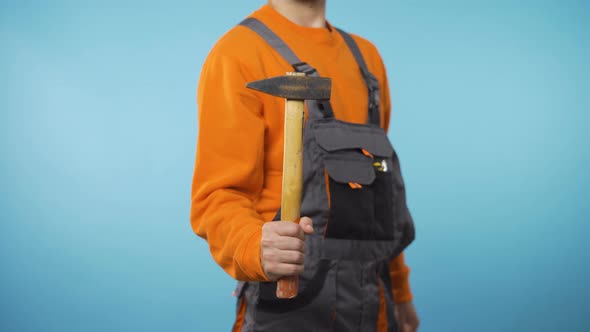 Unrecognizable Repairman Holding a Hammer in One Had alt