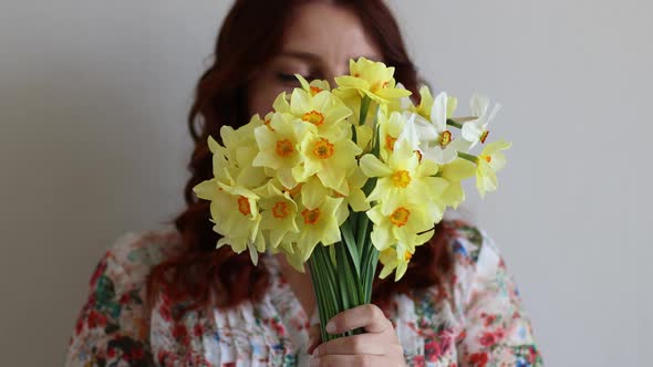 Portrait of Young Romantic Woman Smelling Yellow Daffodils Flowers in Bouquet