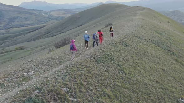 A Group of Hikers Walk the Hill Top at the Dusk alt